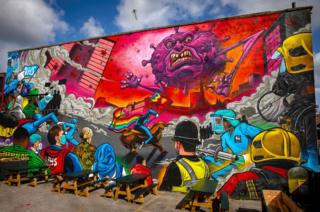 Street art showing key workers fighting "Covid-19"