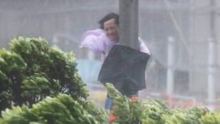 Un hombre en medio de una tormenta en Hong Kong