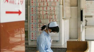 Медсестра носит маску для защиты от тяжелого острого респираторного синдрома (SARS), 2004 г.