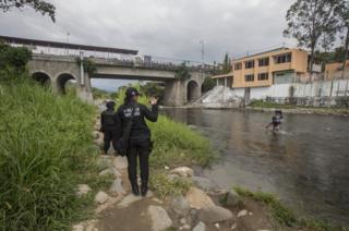 La sargento López haciendo señas a un hombre en el río.