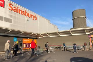 Shoppers observed social distancing as they queue outside Sainsbury's