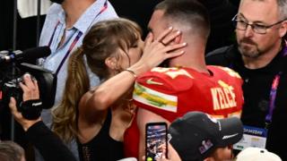 Taylor Swift and Tracis Kelce share a kiss
