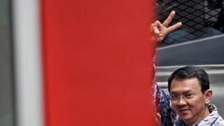 Басуки Тяхаджа Пурнама поднимает руку, когда он прибывает в тюрьму Сипинанг в Джакарте, 9 мая