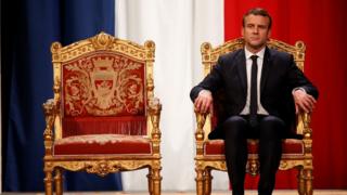 Emmanuel Macron sandalyede oturuyor