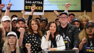 SAG-AFTRA union President Fran Drescher, Duncan Crabtree-Ireland, SAG-AFTRA National Executive Director and Chief Negotiator, and union members gesture at SAG-AFTRA offices