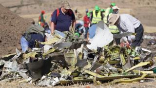 Investigators inspect the wreckage of an airplane