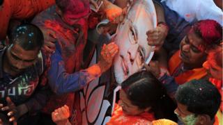 Индийские сторонники партии «Бхаратия джаната» (БДП) празднуют возле офиса партии, поскольку голоса в государственном собрании подсчитываются в Лакхнау 11 марта 2017 года.