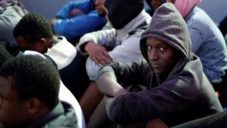 Young man wey sidon for ground with other people