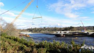 Drochaid Muileann an Tuilm 's i ga togail.