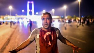 Окровавленный мужчина стоит возле Босфорского моста в Стамбуле