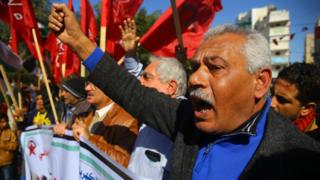 A man raises his fist during protests in Gaza over the electricity supply