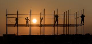   Workers working on the construction of forests at sunset 