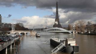 A picture taken on January 26, 2018, shows the flooded banks of the river Seine with the Eiffel Tower in the background in Paris.