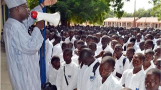 Ọkunrin kan n ba awọn akẹkọ ileewe kan sọrọ ni ita gbangba