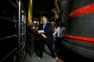 British Foreign Secretary Boris Johnson hits a bell while visiting Shwedagon Pagoda in Yangon, Myanmar