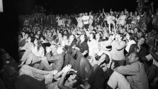 Multitud viendo la transmisión en vivo de la llegada del Apolo 11 a la Luna.