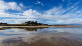 Clouds reflected in water on a beach