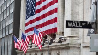 Flags fly at full staff outside the NYSE on 9 April 2020 in New York City