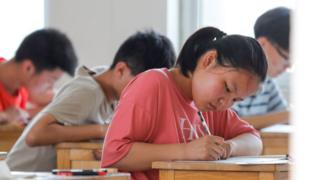 A student takes an exam during the first day of the National College Entrance Examination (NCEE), known as Gaokao