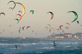 Kite surfers kitesurf in good wind and weather on February 6, 2019, in Tableview, about 15km from the centre of Cape Town.