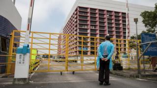身穿疫病防护衣物的保安员在香港上水屠房外站岗(13/5/2019)