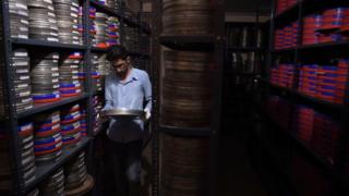 An employee taking a film reel to be digitised at the state-run Afghan Film department in Kabul
