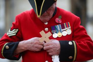 A Chelsea Pensioner holds a cross in the Field of Remembrance at Westminster Abbey in London