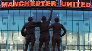 Les statues de George Best, Denis Law et Bobby Charlton devant le stade de Manchester United, 2e du championnat.