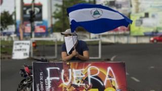 A young man raises the national flag of Nicaragua during a protest in support of the city of Masaya in Managua, Nicaragua, 04 June 2018.