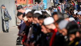 Russian National Guard members line up as Muslims attend morning prayers in Moscow, Russia