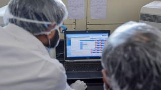 Employees of Dr Lal PathLabs, that provides diagnostic and health tests, check results of coronavirus tests at their lab during a government-imposed nationwide lockdown as a preventive measure against the COVID-19 coronavirus, in New Delhi on April 2, 2020.