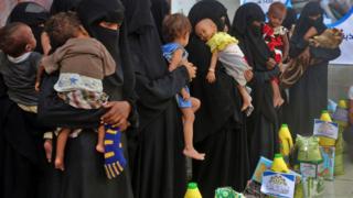 Mujeres haciendo fila para recibir alimentos