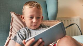 niño usando teléfono móvil