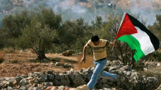 فلسطيني يحمل علم بلاده