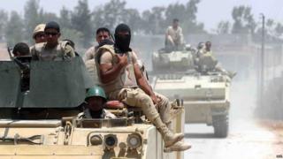 Военнослужащие египетских вооруженных сил на бронетехнике патрулируют улицу в районе города шейха Цувейда на севере Синайского полуострова (13 июля 2015 года)