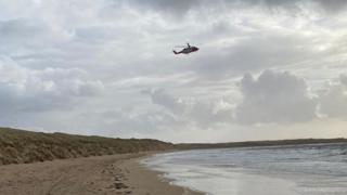 A helicopter flying over Bunbeg beach