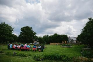 Participants and volunteers sit together for a meal at a long table