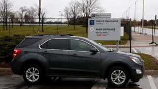 A car drives by the General Motors Detroit-Hamtramck Assembly, one of the plants where GM will stop production