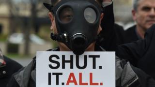 A Porter Ranch resident wearing a gas mask as he joins others in a protest outside a meeting of the Air Quality Management Board (23 January 2016)