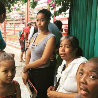 Pessoas nas proximidades do porto de La Guaira, na Venezuela, à espera de assistência médica