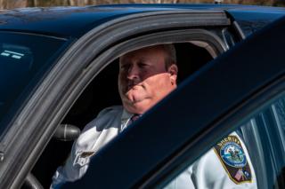 Sheriff Scott Jenkins in his patrol car. He has offered to deputise thousands of citizens