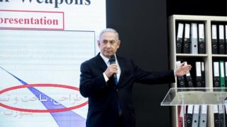 Премьер-министр Израиля Биньямин Нетаньяху на сцене представляет документы, предположительно похищенные из иранского ядерного архива
