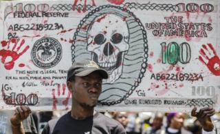 Kenyan activists raise a mock US dollar bill during a protest against the politicians and leaders of war-torn South Sudan, in Nairobi, Kenya, 11 October 2018.