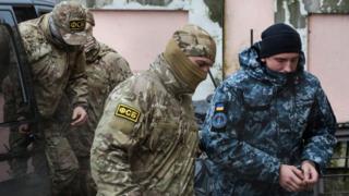 A Russian FSB security service officer escorts a detained Ukrainian sailor to a courthouse in Simferopol, Crimea, on November 27, 2018