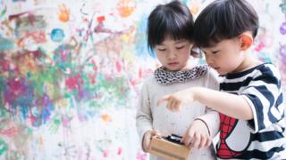 Children play a record player developed by Oreo in a kindergarten in east China's Zhejiang province, on May 12, 2017 in Hangzhou, China. The player can record sounds and change music according to cookies placed on it.