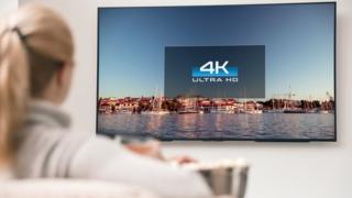 Woman watching a television in 4K.