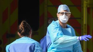 Doctors wearing protective equipment are seen loading a patient in to an ambulance outside St Thomas' Hospital on April 7, 2020
