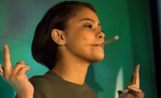 A woman wins a round of a joint-rolling competition at the Cannabis Expo in Cape Town, South Africa - Saturday 6 April 2019