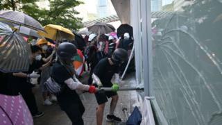 Manifestantes rompiendo cristales para entrar al edificio