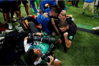Croatia players celebrate next to an AFP photographer Yuri Cortez after Mario Mandzukic scores their second goal